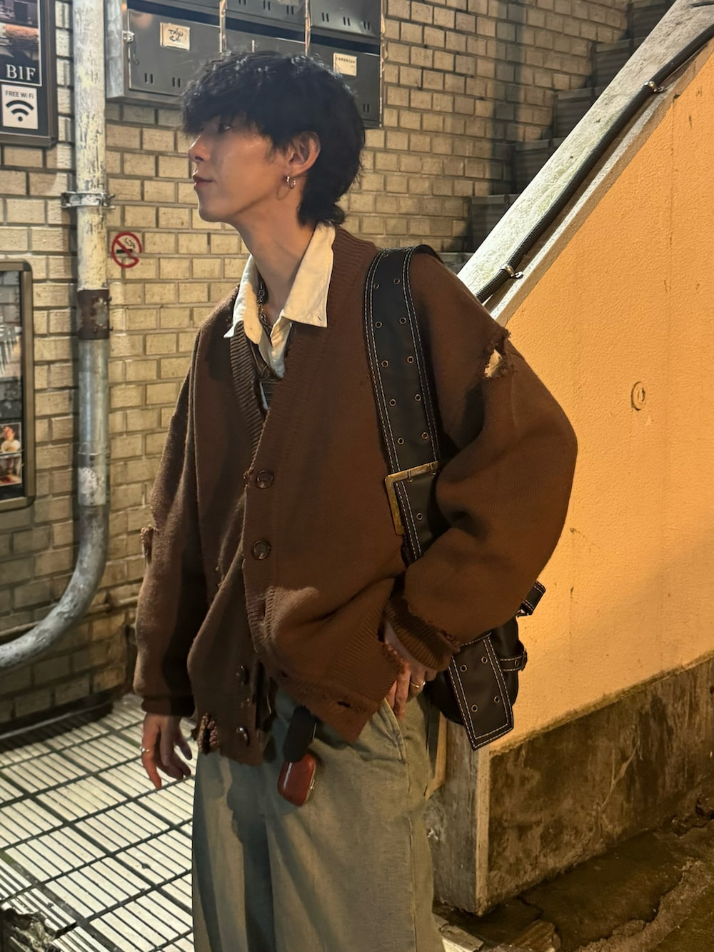 ブラウン系のカーディガン/ボレロ、ベージュ系のデニムパンツ、ブラック系のショルダーバッグを着用したメンズの秋コーディネートの3枚目の写真