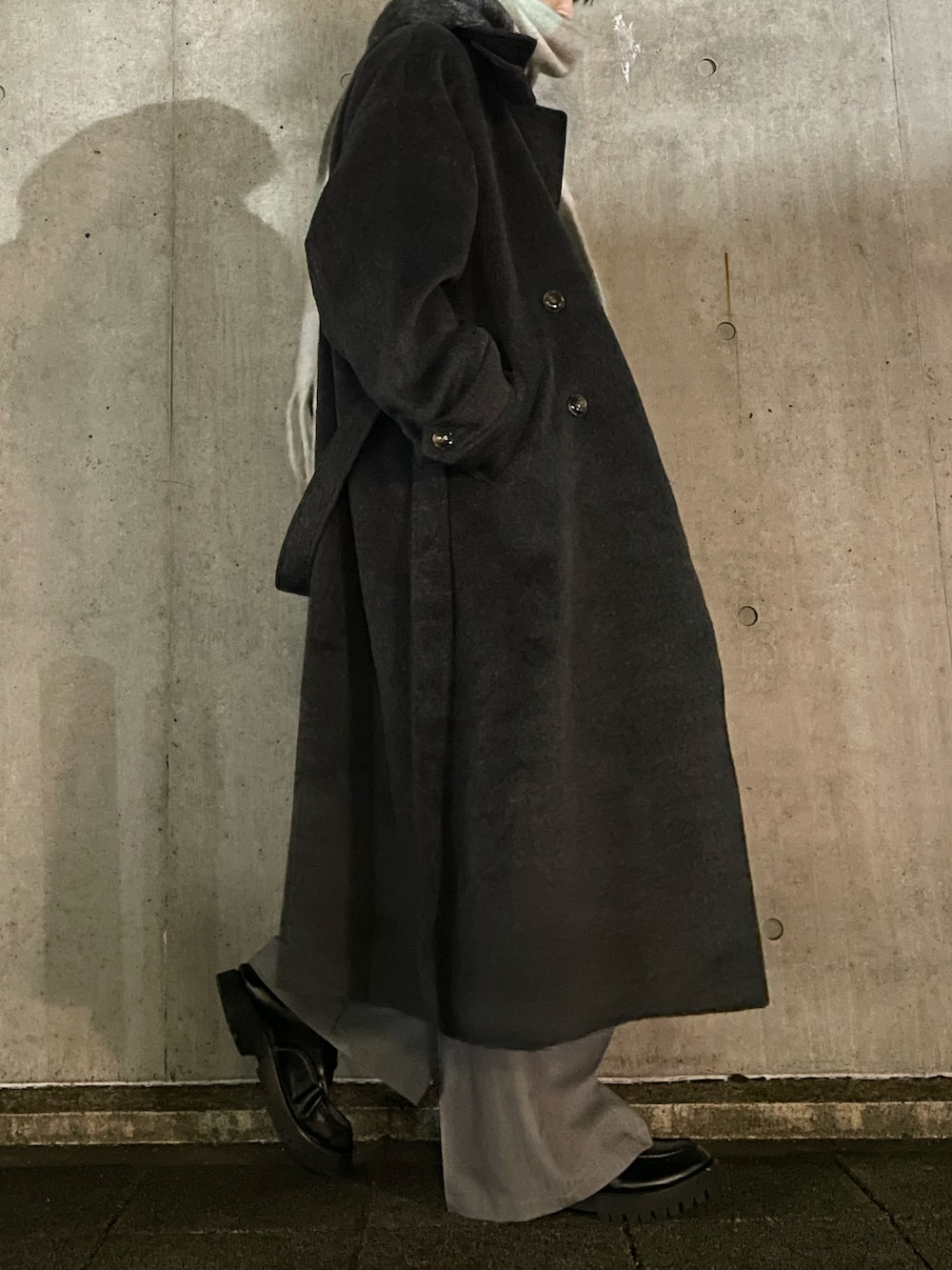 グレー系のスラックス、ブラック系のローファー、グレー系のニット/セーターを着用したメンズの冬コーディネートの3枚目の写真