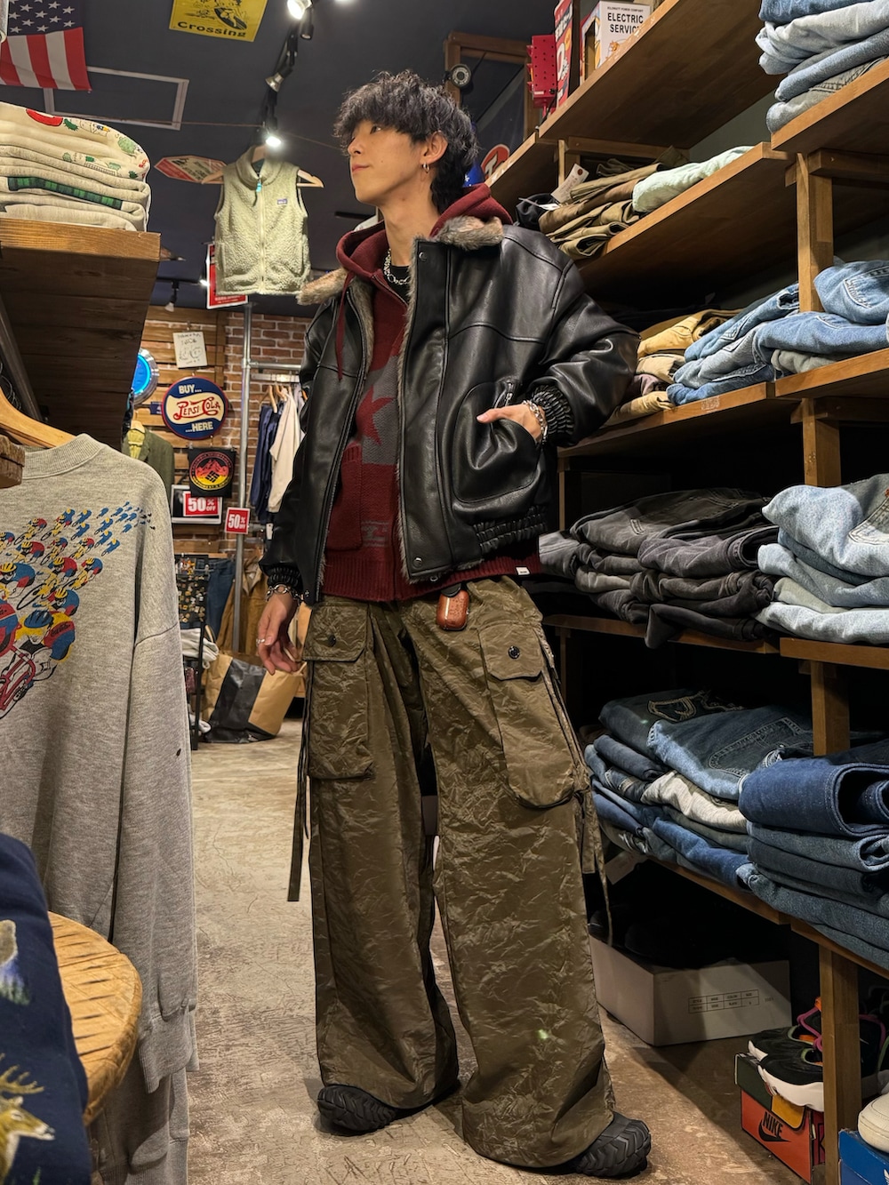 ブラック系のその他アウター、レッド系のパーカー、グリーン系のスラックスを着用したメンズの冬コーディネートの2枚目の写真