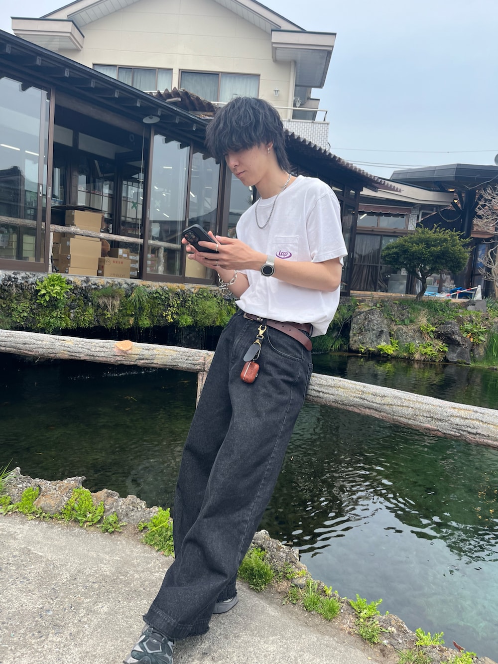 ホワイト系のTシャツ/カットソー、ブラック系のデニムパンツ、ブラック系のスニーカーを着用したメンズの夏コーディネートの2枚目の写真