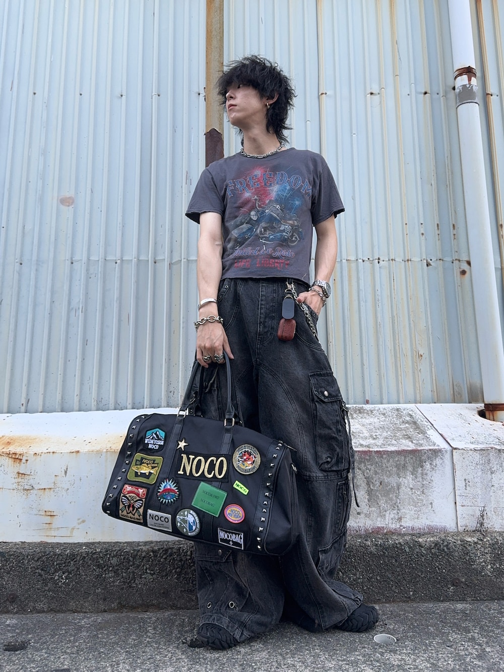 グレー系のTシャツ/カットソー、ブラック系のデニムパンツ、ブラック系のボストンバッグを着用したメンズの秋コーディネートの2枚目の写真