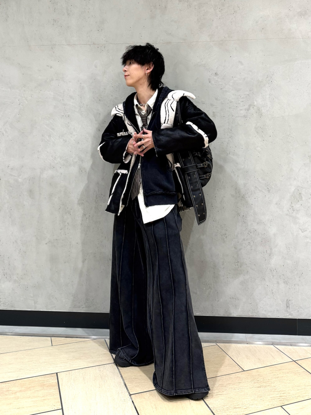 ブラック系のブルゾン、ブラック系のパーカー、ブラウン系のネクタイを着用したメンズの冬コーディネートの2枚目の写真