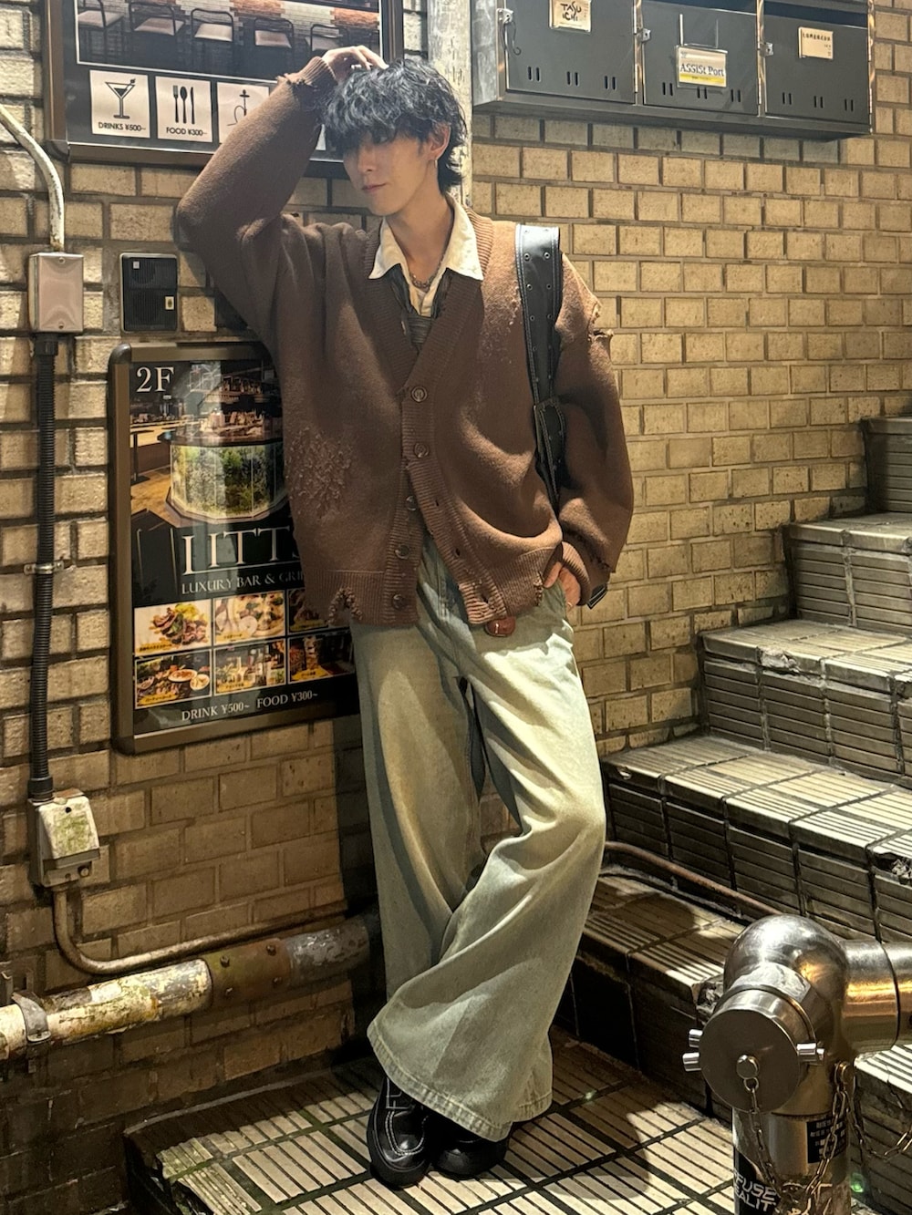 ブラウン系のカーディガン/ボレロ、ベージュ系のデニムパンツ、ブラック系のショルダーバッグを着用したメンズの秋コーディネートの2枚目の写真