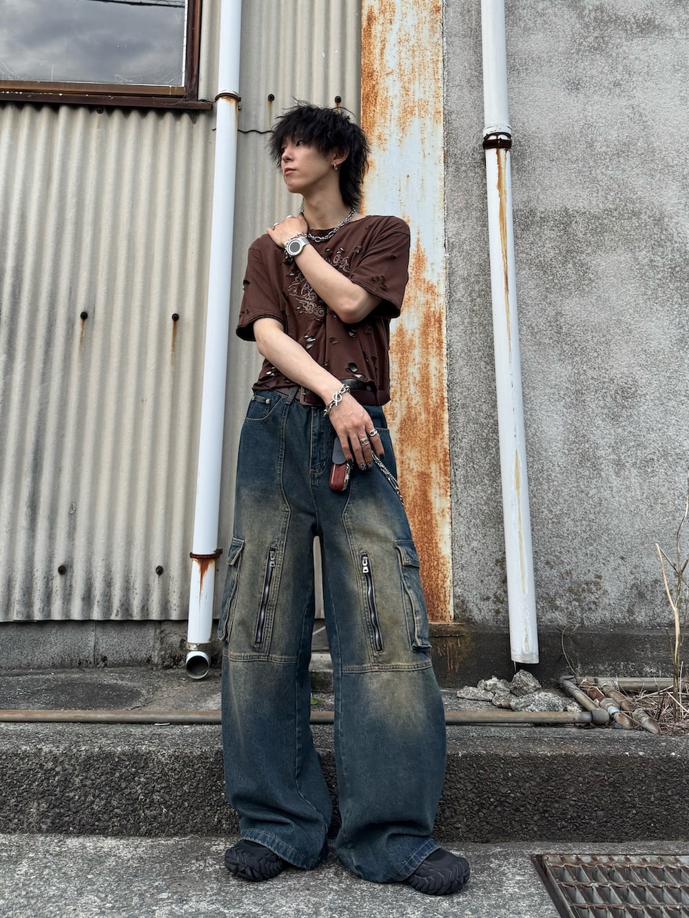 ブラウン系のTシャツ/カットソー、グリーン系のデニムパンツ、ブラック系のスニーカーを着用したメンズの夏コーディネートの2枚目の写真