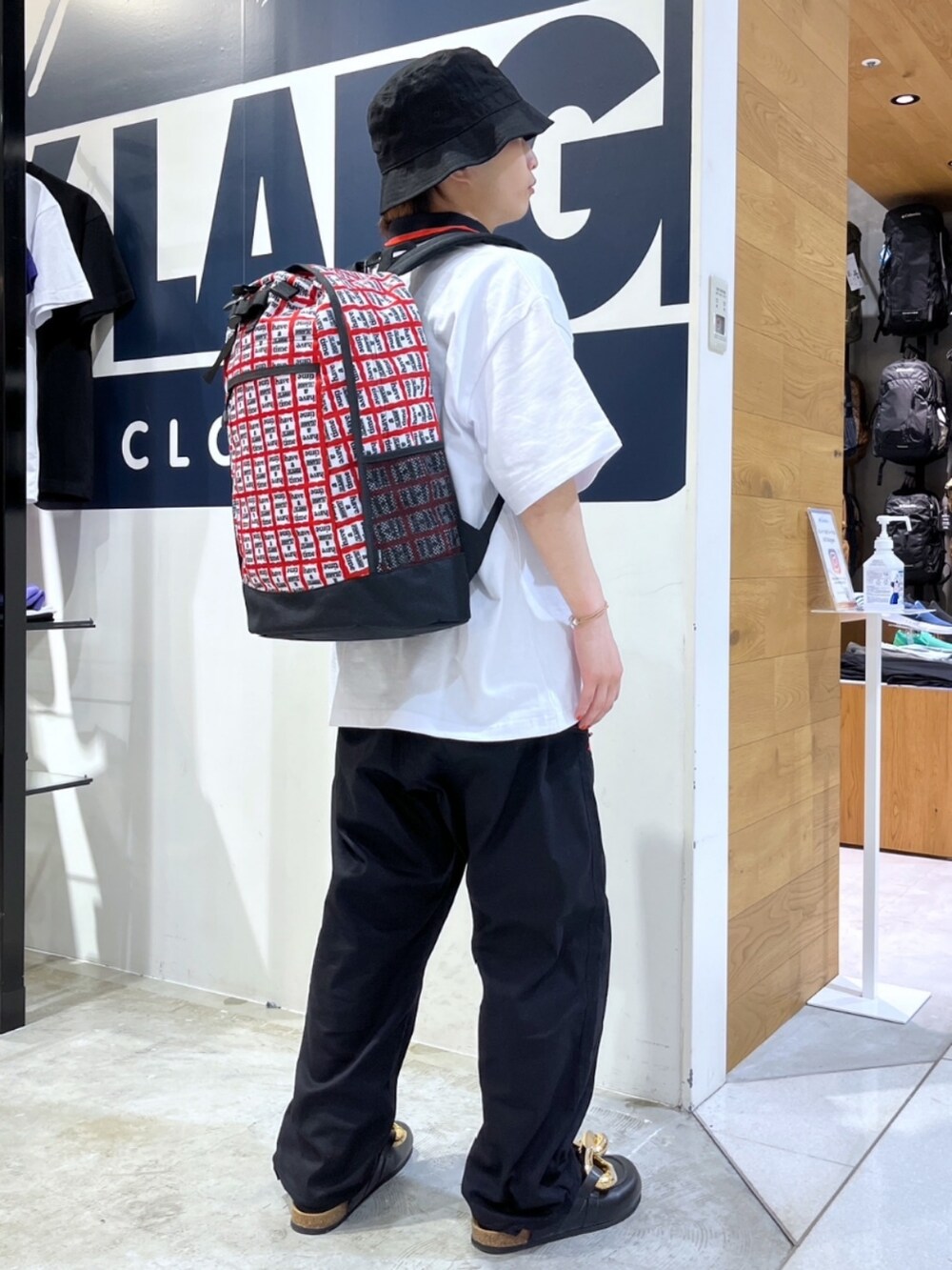 ブラック系のその他パンツ、ブラック系のローファー、ホワイト系のポロシャツを着用したメンズの春コーディネートの2枚目の写真