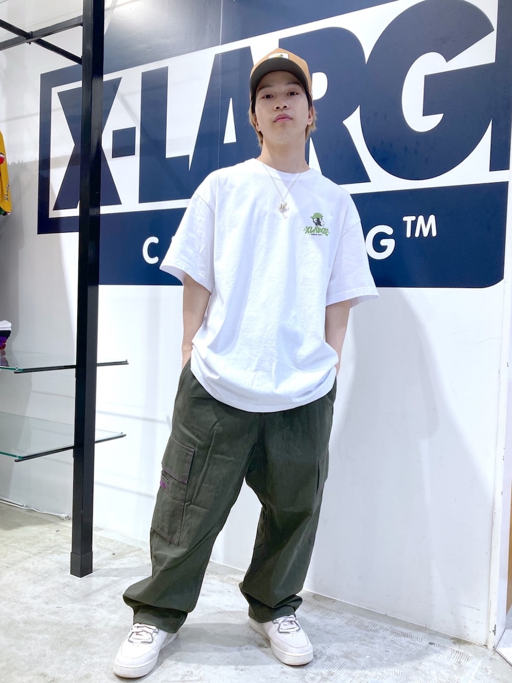 グリーン系のカーゴパンツ、ホワイト系のTシャツ/カットソー、ベージュ系のキャップを着用したメンズの夏コーディネートの3枚目の写真
