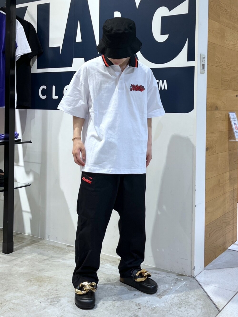 ブラック系のその他パンツ、ブラック系のローファー、ホワイト系のポロシャツを着用したメンズの春コーディネートの5枚目の写真