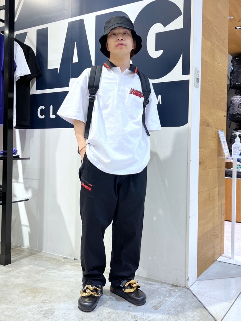 ブラック系のその他パンツ、ブラック系のローファー、ホワイト系のポロシャツを着用したメンズの春コーディネートの3枚目の写真