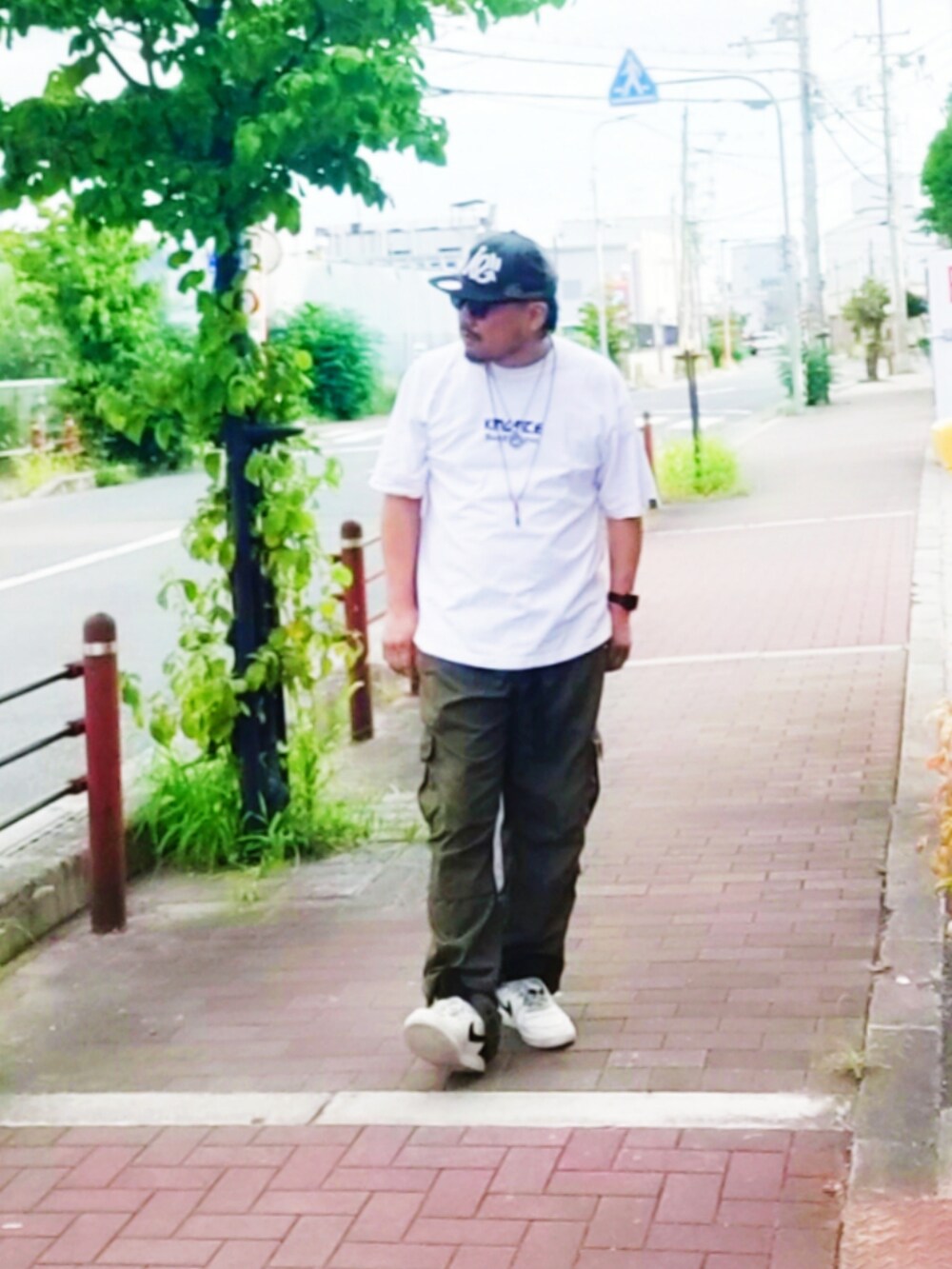 ホワイト系のTシャツ/カットソー、グリーン系のカーゴパンツ、ホワイト系のスニーカーを着用したメンズの夏コーディネートの5枚目の写真