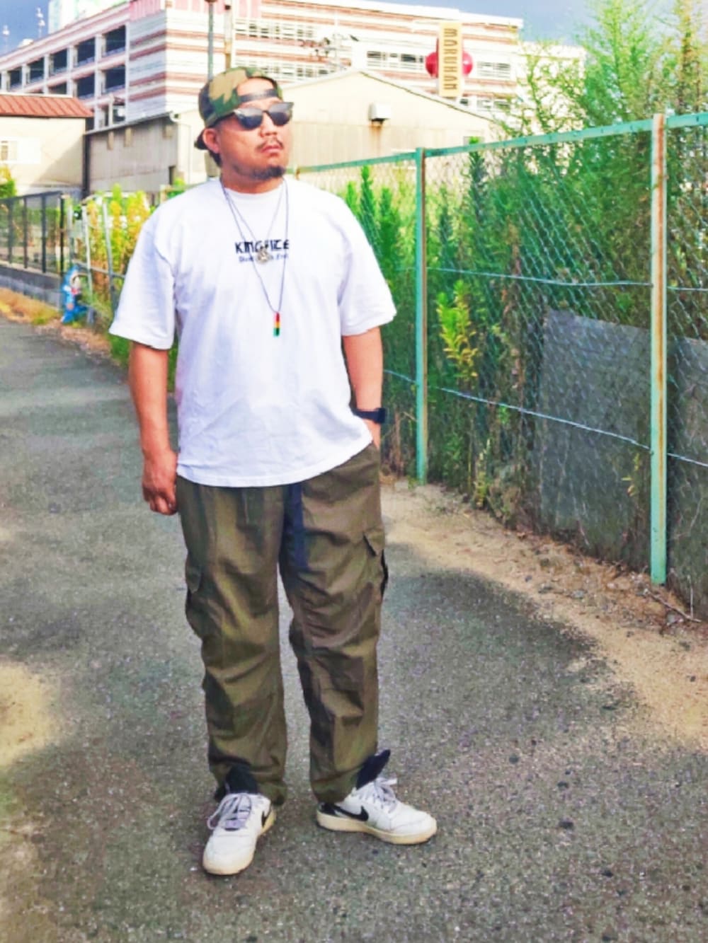 ホワイト系のTシャツ/カットソー、グリーン系のカーゴパンツ、ホワイト系のスニーカーを着用したメンズの夏コーディネートの3枚目の写真
