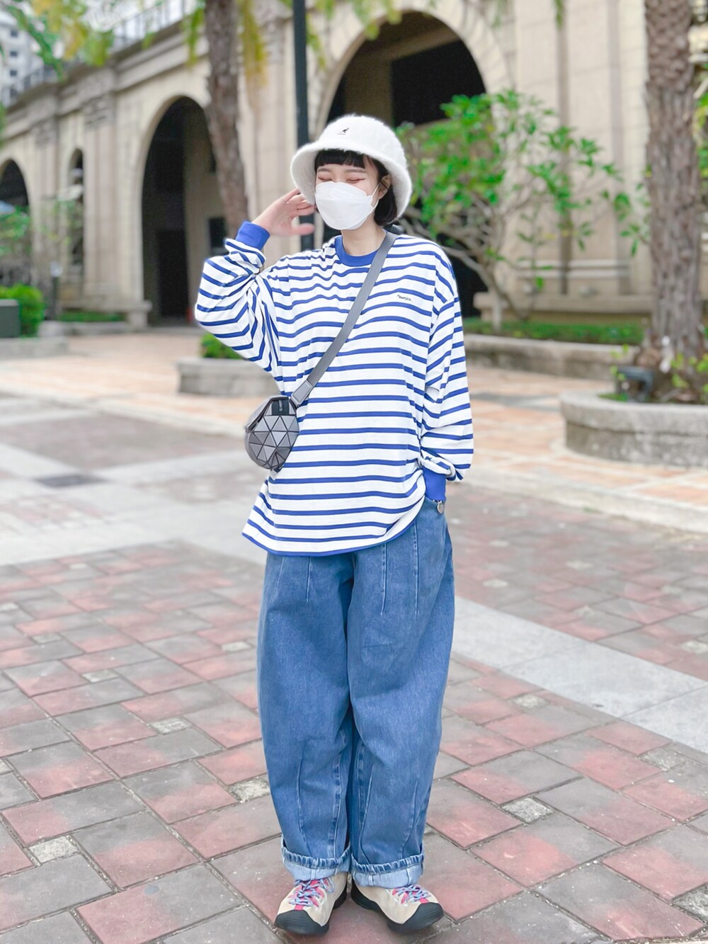 ブルー系のTシャツ/カットソー、グレー系のメッセンジャーバッグ、ピンク系のスニーカーを着用したレディースの冬コーディネートの2枚目の写真