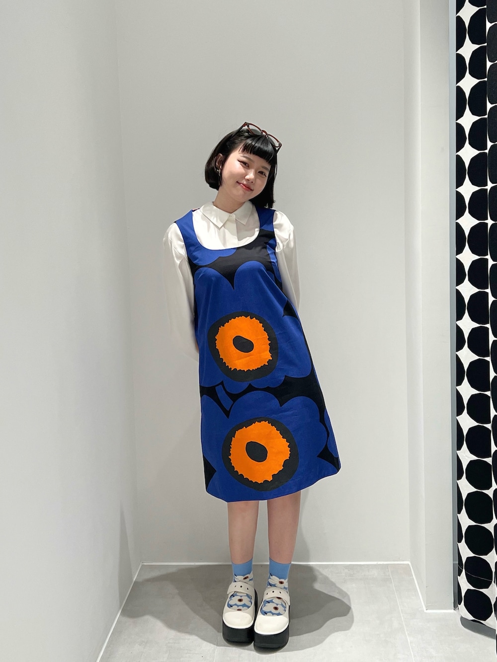 ブルー系のジャンパースカート、ホワイト系のレインシューズ、ブルー系のソックス/靴下を着用したレディースの夏コーディネートの2枚目の写真