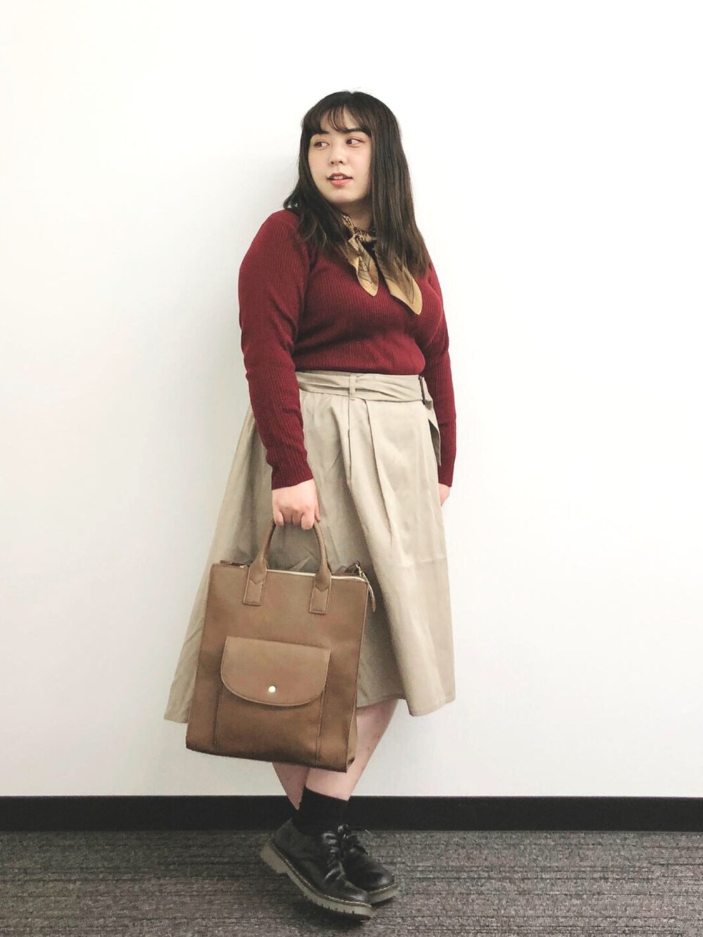 ブラウン系のバッグ、ベージュ系のスカート、ブラック系のシューズを着用したレディースの秋コーディネートの5枚目の写真