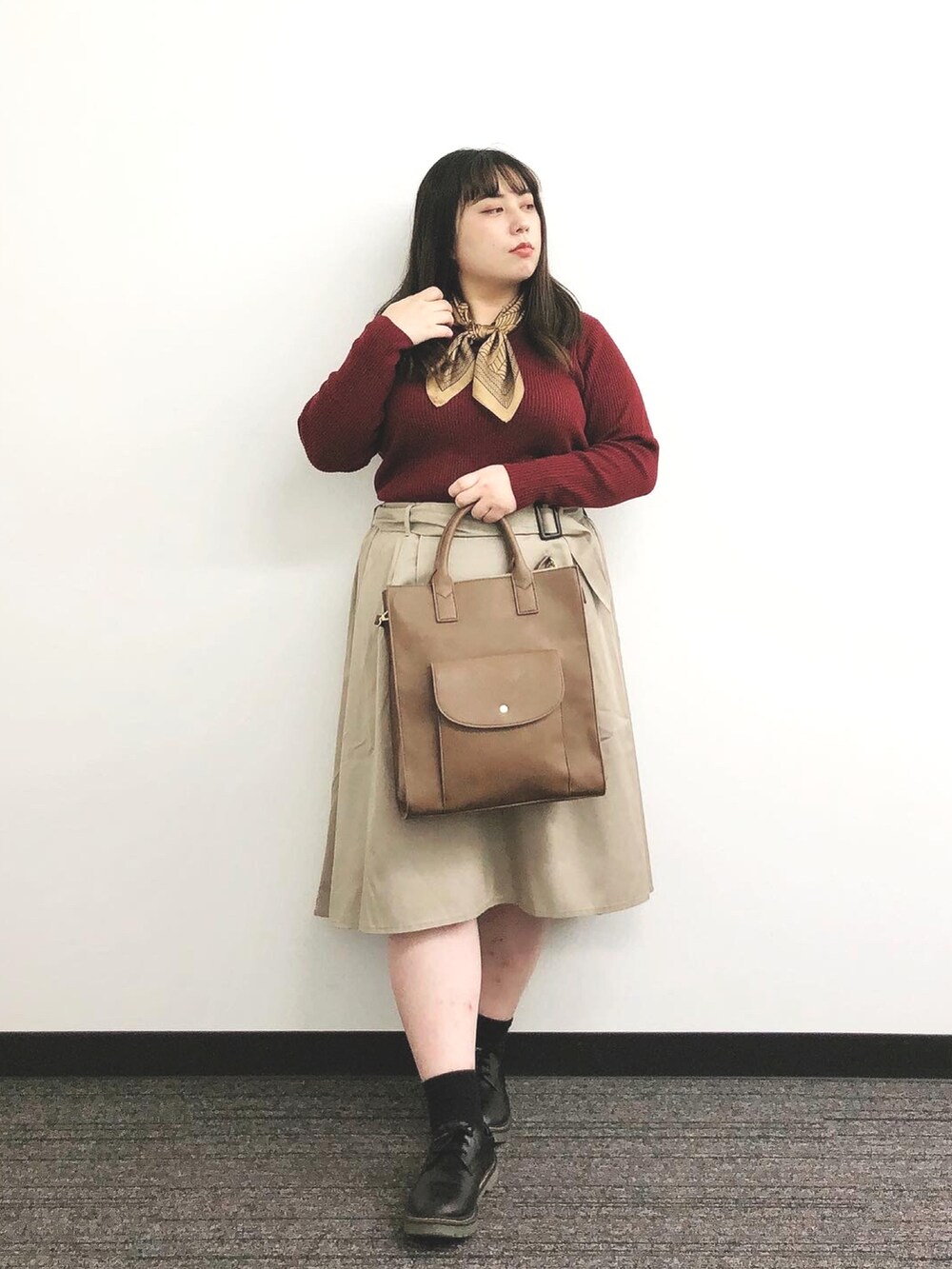 ブラウン系のバッグ、ベージュ系のスカート、ブラック系のシューズを着用したレディースの秋コーディネートの3枚目の写真