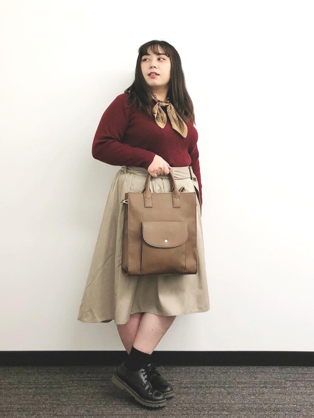 ブラウン系のバッグ、ベージュ系のスカート、ブラック系のシューズを着用したレディースの秋コーディネートの2枚目の写真