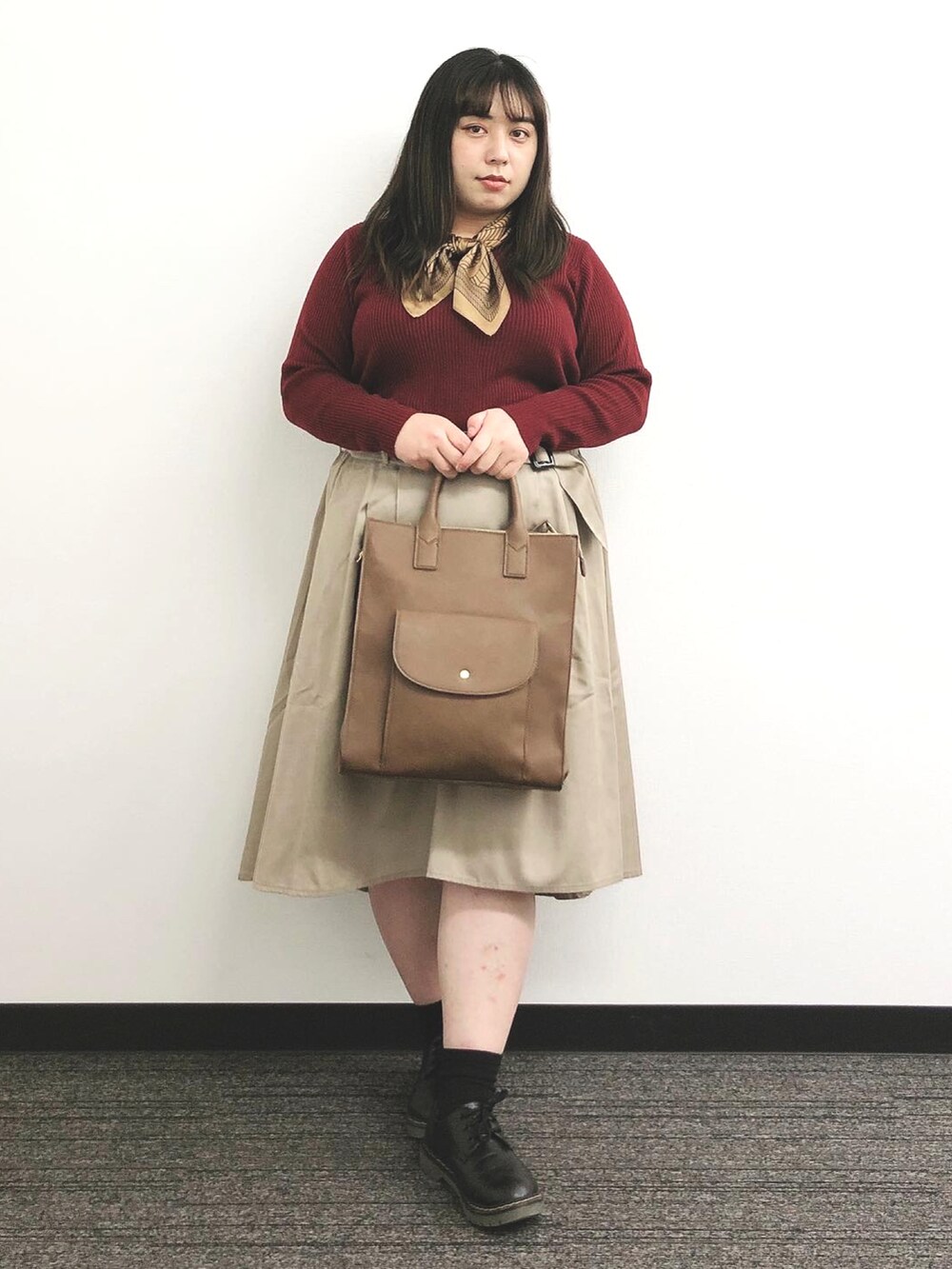 ブラウン系のバッグ、ベージュ系のスカート、ブラック系のシューズを着用したレディースの秋コーディネートの4枚目の写真