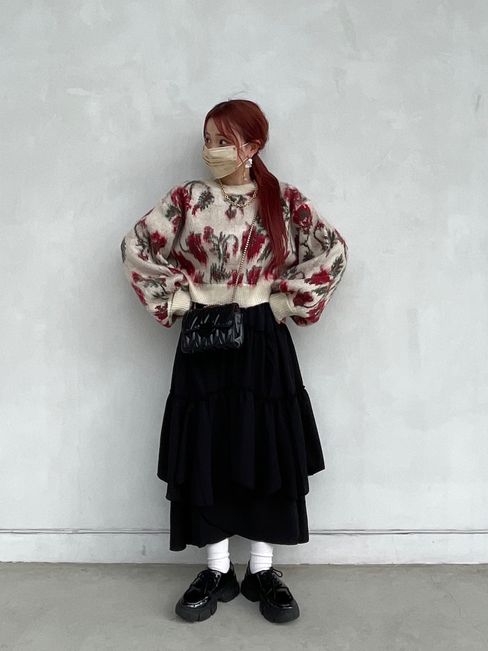 ホワイト系のカーディガン/ボレロ、ブラック系のスカート、ブラック系のドレスシューズを着用したレディースの冬コーディネートの2枚目の写真