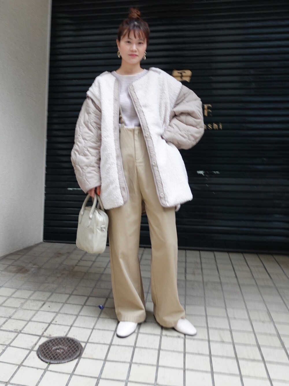 ホワイト系のブルゾン、ベージュ系のTシャツ/カットソー、ベージュ系のショルダーバッグを着用したレディースの冬コーディネートの2枚目の写真