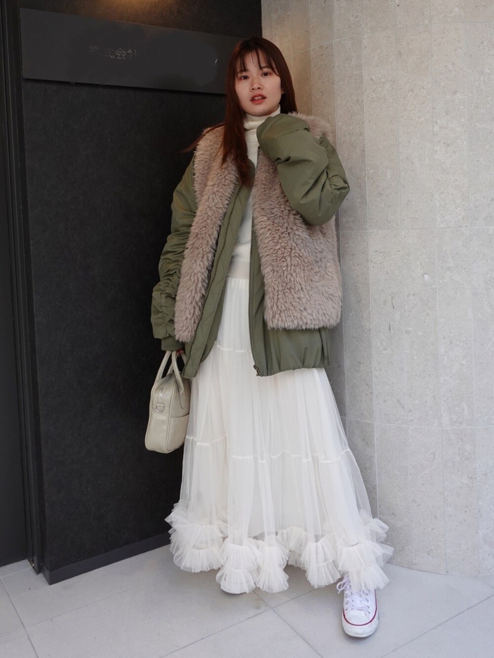 ホワイト系のスカート、ホワイト系のスニーカー、ベージュ系のショルダーバッグを着用したレディースの冬コーディネートの2枚目の写真