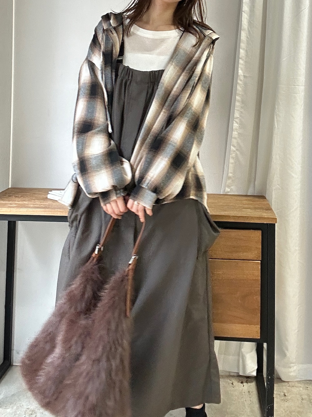 グレー系のジャンパースカート、ブラウン系のシャツ/ブラウス、ブラウン系のショルダーバッグを着用したレディースの秋コーディネートの2枚目の写真
