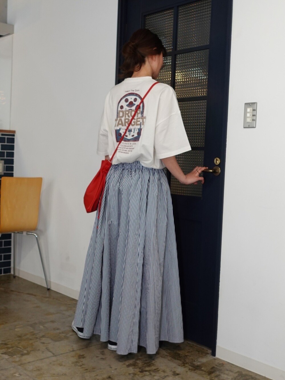 グリーン系のショルダーバッグ、ブルー系のスカートを着用したレディースの春コーディネートの2枚目の写真