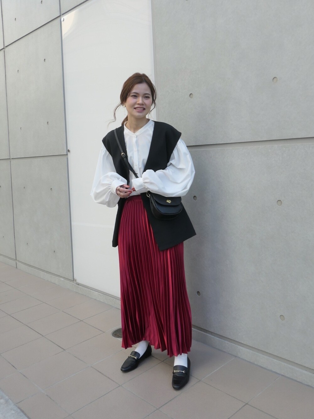 ホワイト系のシャツ/ブラウス、ブラック系のベスト、レッド系のスカートを着用したレディースの冬コーディネートの2枚目の写真