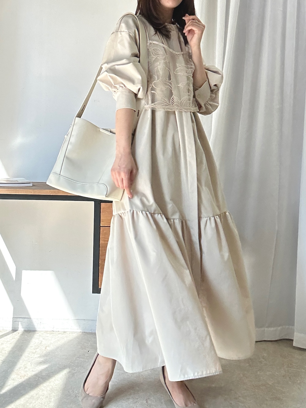 ベージュ系のシャツワンピース、ベージュ系のキャミソール、ホワイト系のショルダーバッグを着用したレディースの夏コーディネートの2枚目の写真