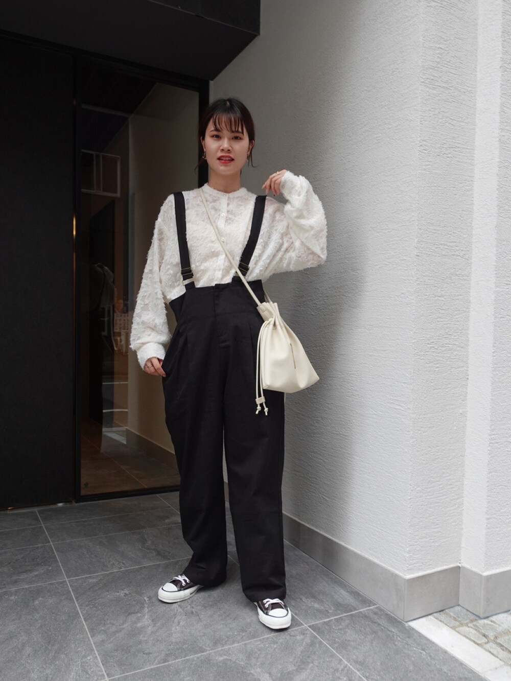 ブラック系のサロペット/オーバーオール、ベージュ系のシャツ/ブラウス、ホワイト系のショルダーバッグを着用したレディースの秋コーディネートの2枚目の写真