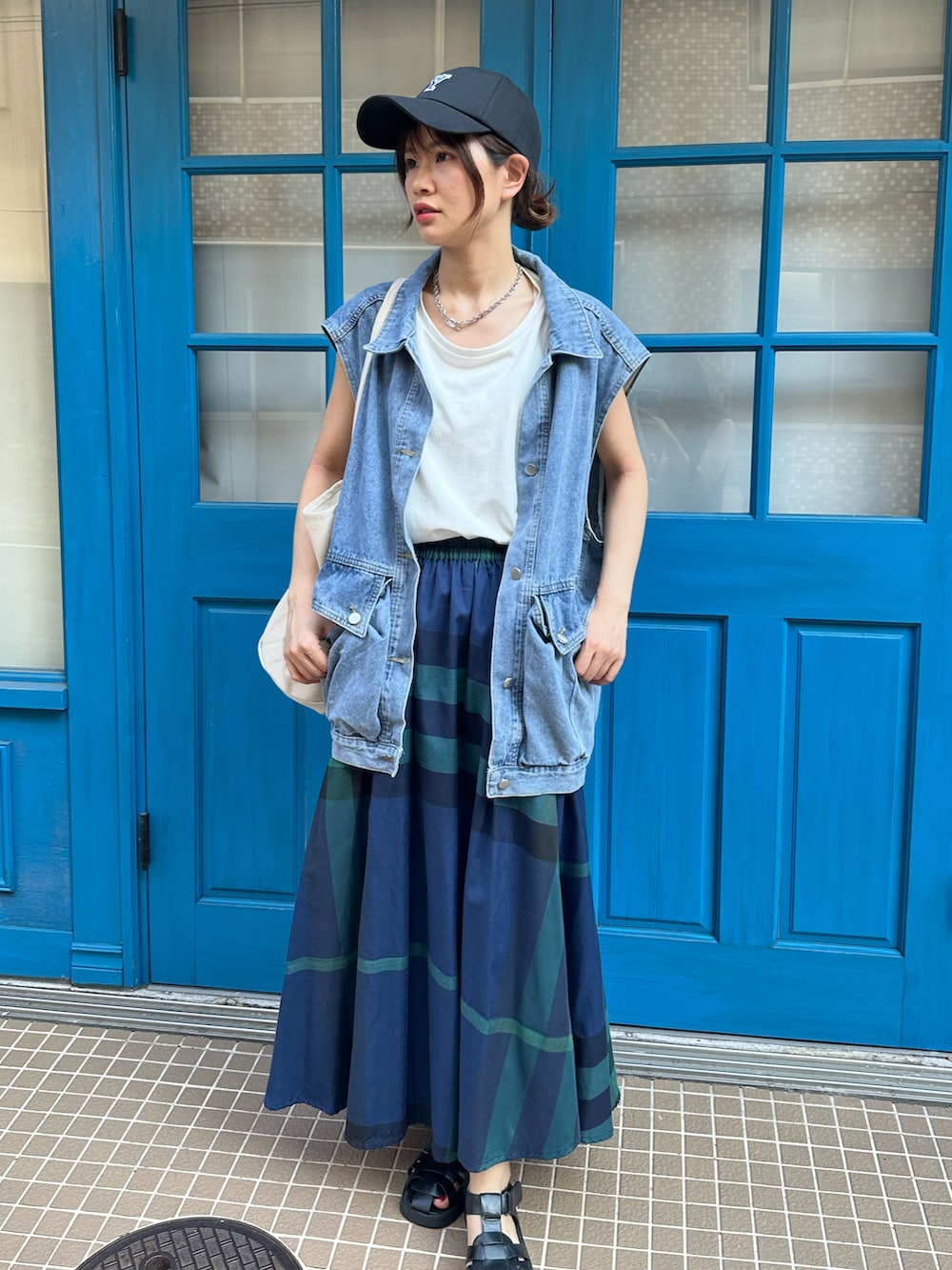 ホワイト系のタンクトップ、ブルー系のスカート、ホワイト系のトートバッグを着用したレディースの夏コーディネートの2枚目の写真