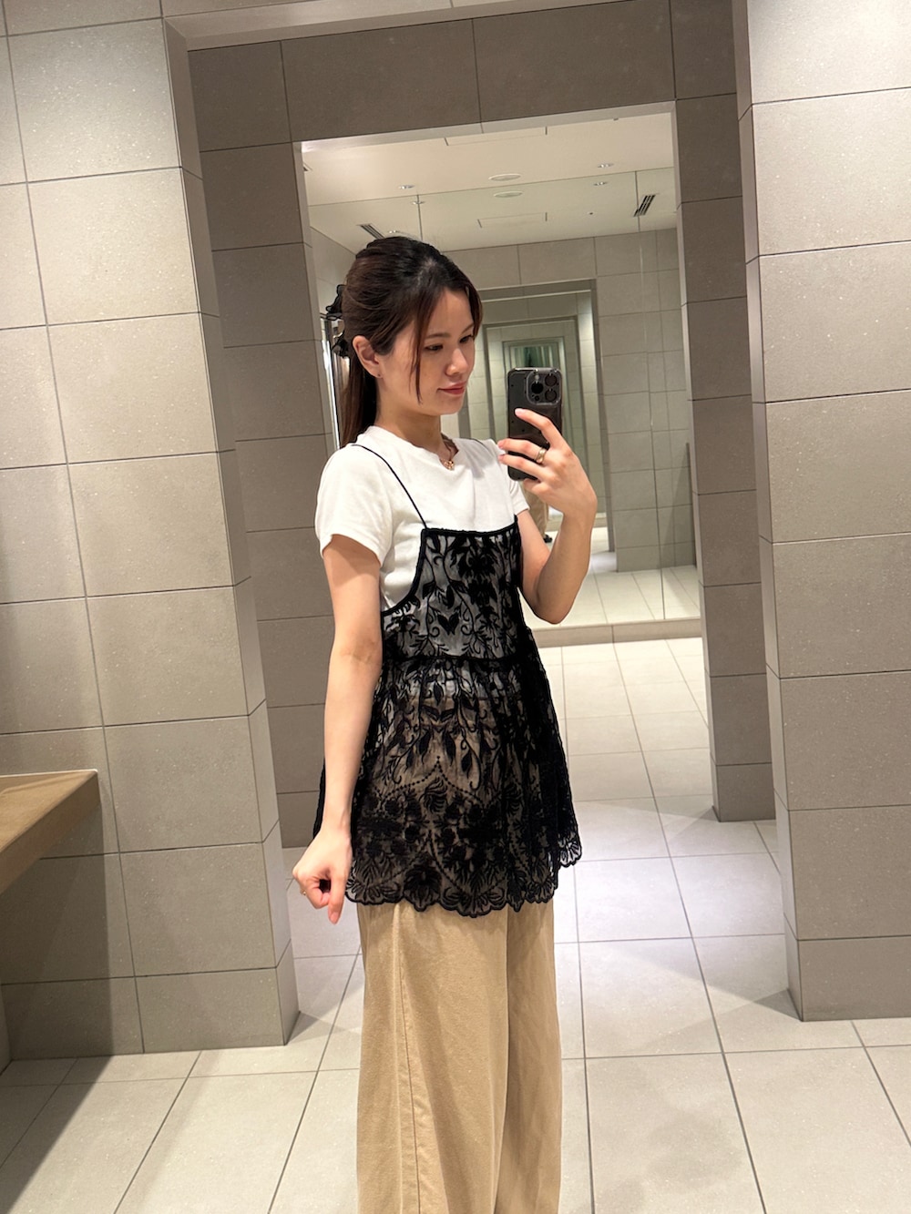 ブラック系のキャミソール、ベージュ系のスラックスを着用したレディースの夏コーディネートの4枚目の写真