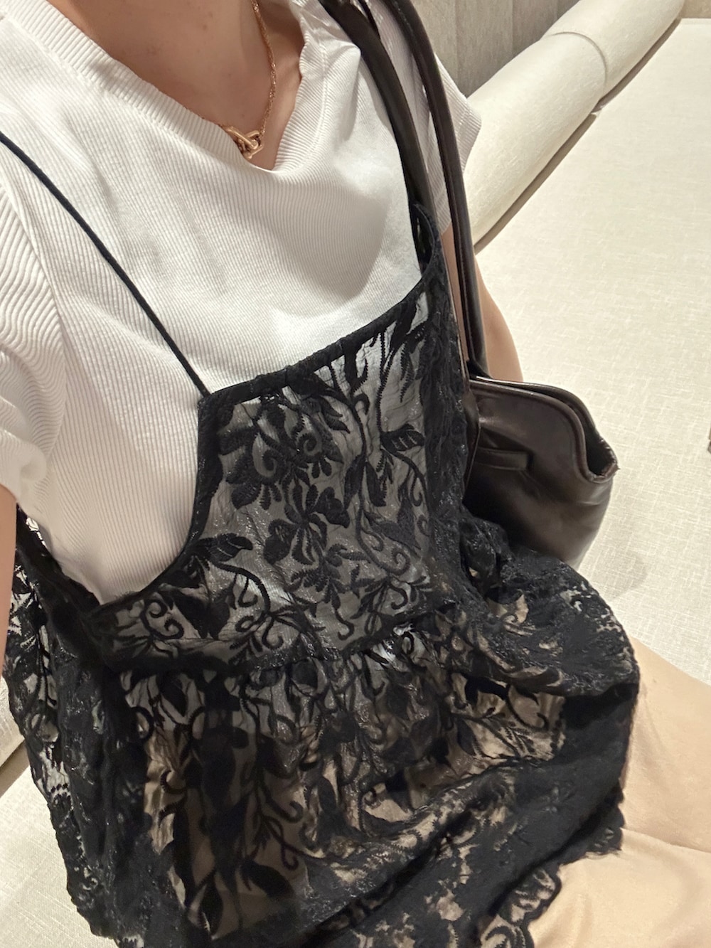 ブラック系のキャミソール、ベージュ系のスラックスを着用したレディースの夏コーディネートの2枚目の写真