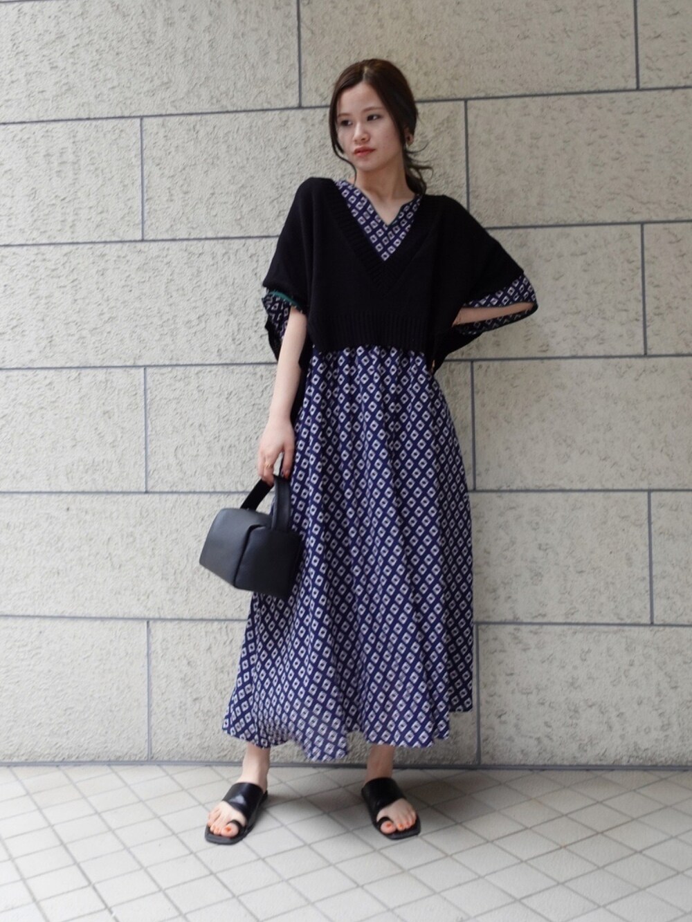 ブラック系のショルダーバッグ、ブルー系のワンピース、ブラック系のベストを着用したレディースの春コーディネートの3枚目の写真