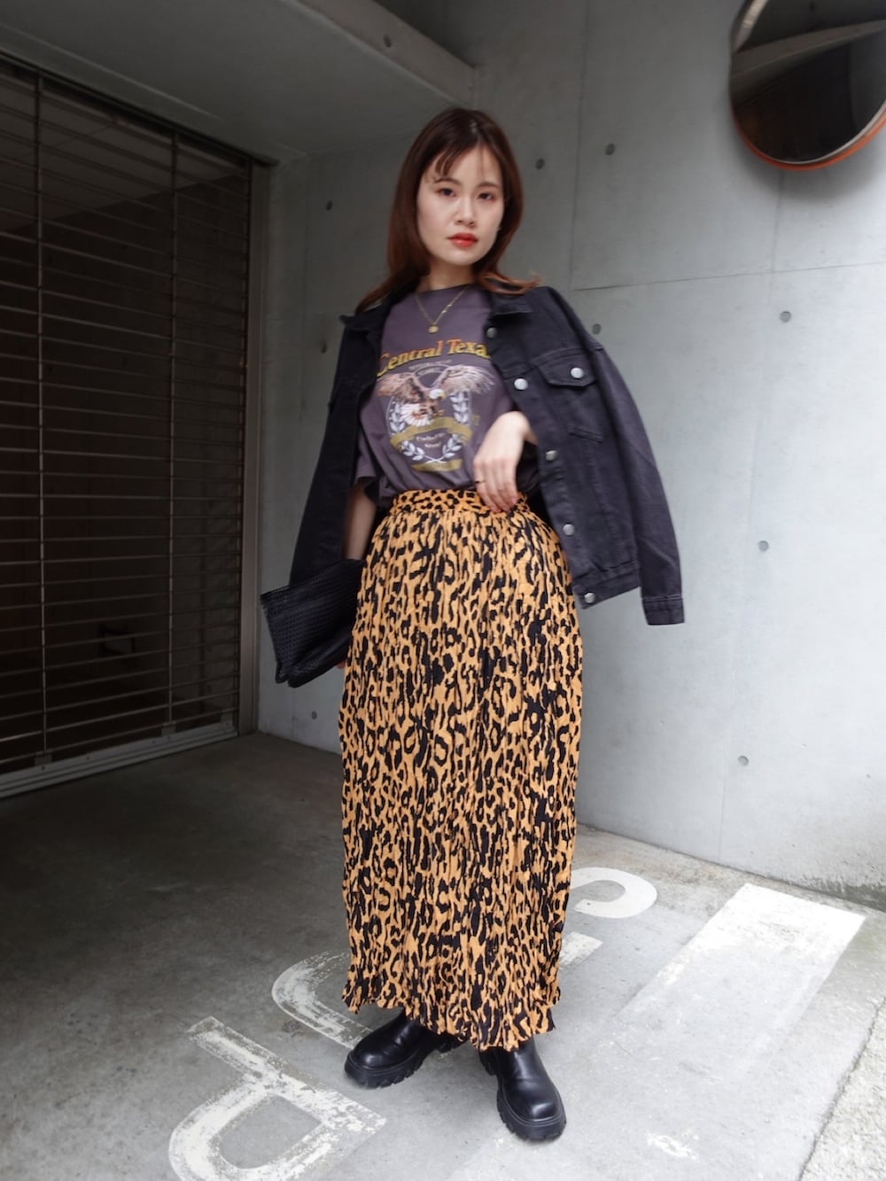 イエロー系のスカート、ブラック系のTシャツ/カットソー、ブラック系のデニムジャケットを着用したレディースの春コーディネートの2枚目の写真