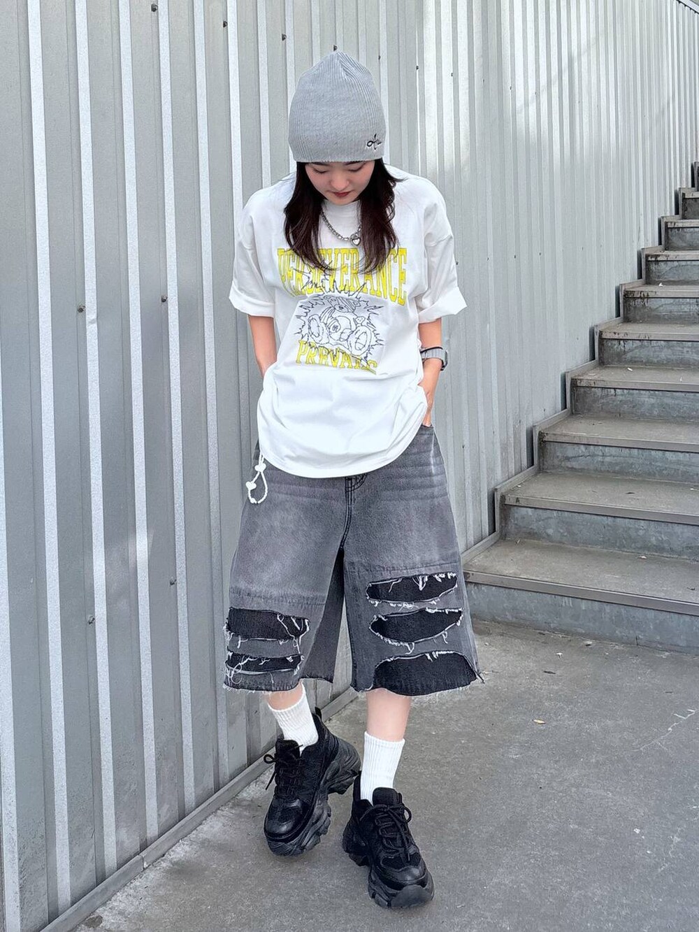 ブラック系のスニーカー、ブラック系のデニムパンツ、ホワイト系のTシャツ/カットソーを着用したレディースの春コーディネートの5枚目の写真