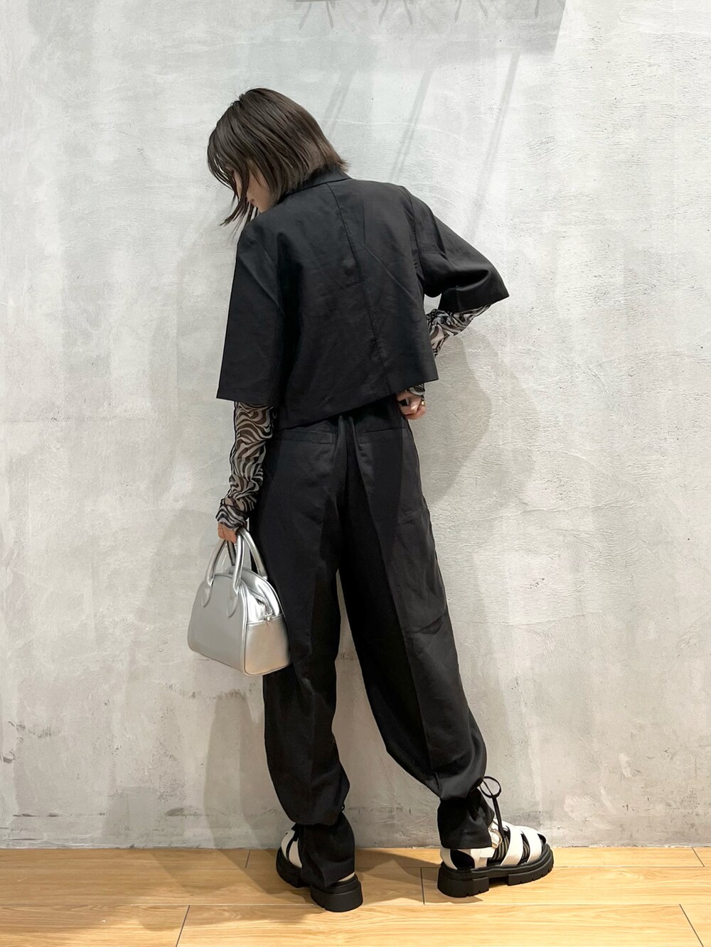 シルバー系のショルダーバッグ、ホワイト系のTシャツ/カットソー、ブラック系のテーラードジャケットを着用したレディースの夏コーディネートの2枚目の写真