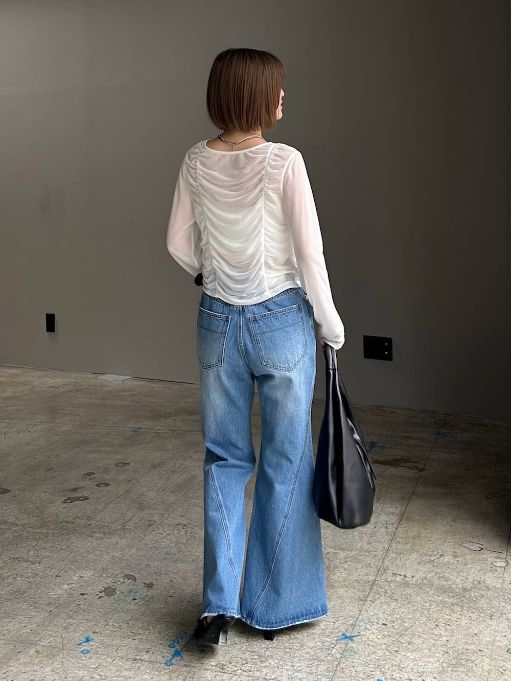 ブルー系のデニムパンツ、ブラック系のトートバッグ、ホワイト系のTシャツ/カットソーを着用したレディースの春コーディネートの3枚目の写真