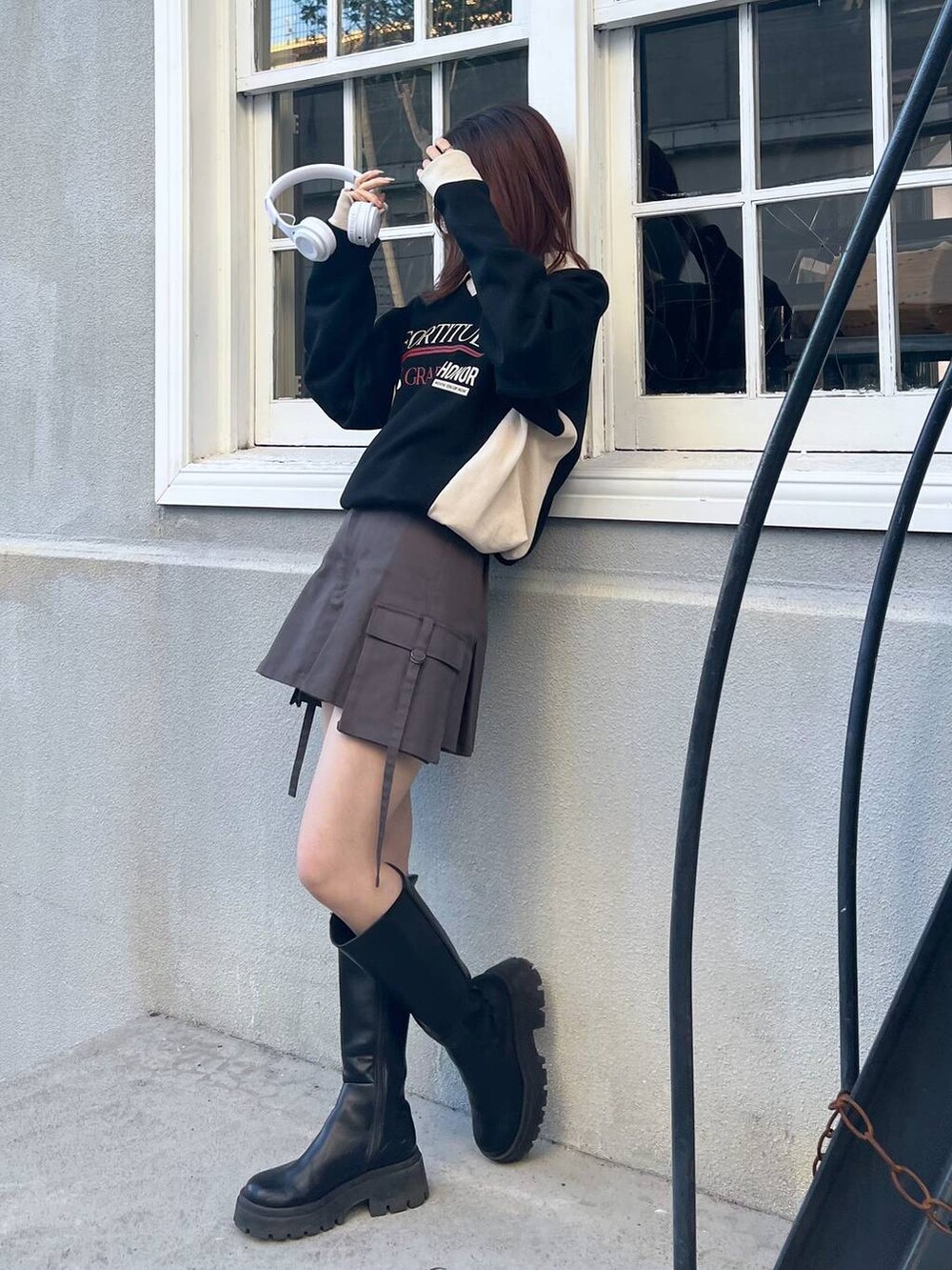 ブラック系のブーツ、グレー系のスカート、ブラック系のスウェットを着用したレディースの冬コーディネートの3枚目の写真