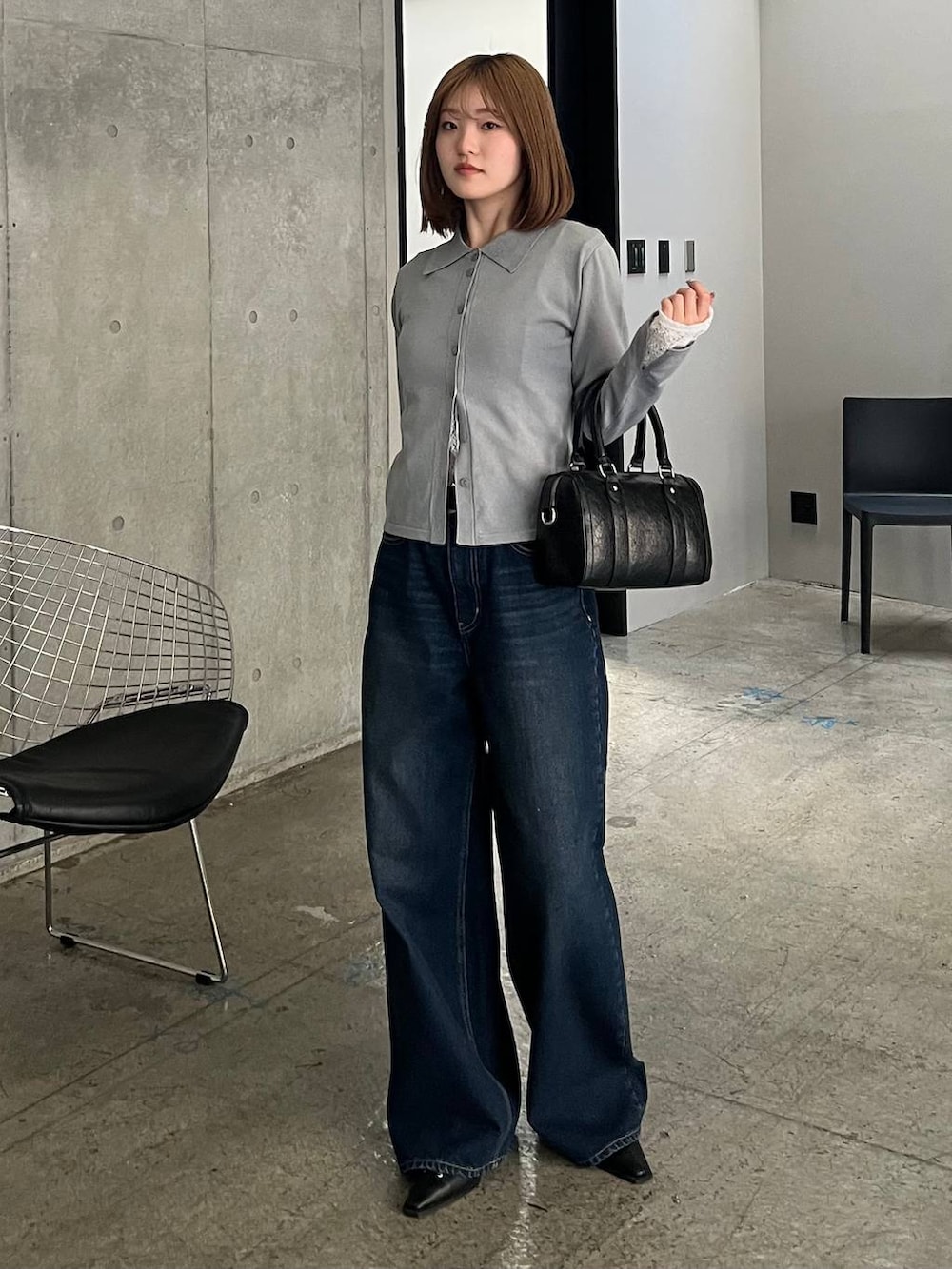 ブルー系のスラックス、ブラック系のボストンバッグ、ブラック系のサンダルを着用したレディースの冬コーディネートの4枚目の写真