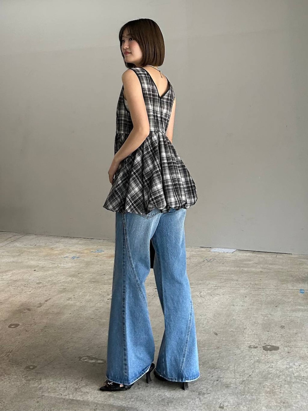 ブルー系のデニムパンツ、ブラック系のボストンバッグ、ブラック系のサンダルを着用したレディースの春コーディネートの6枚目の写真