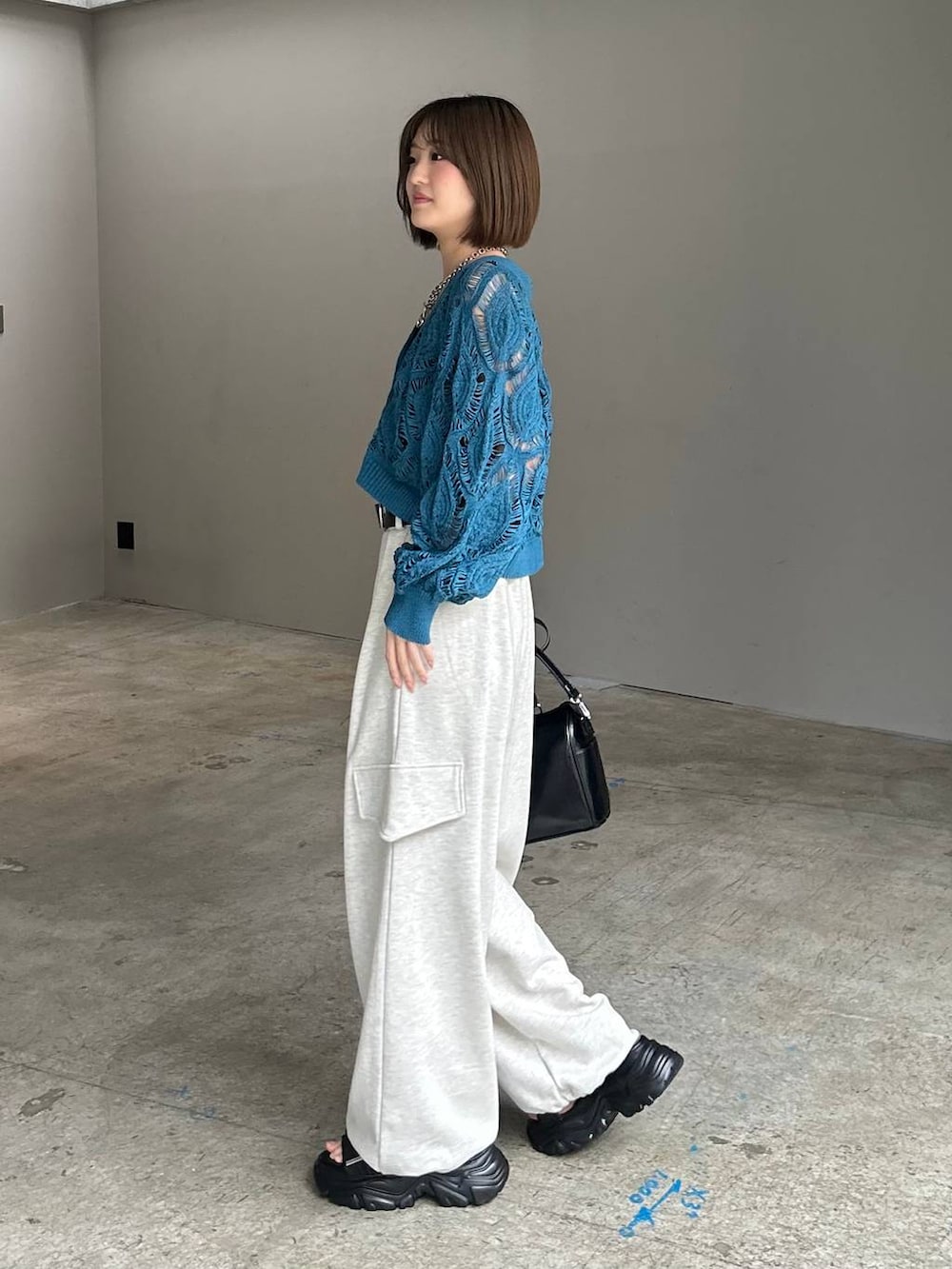 ブルー系のカーディガン/ボレロ、ブラック系のショルダーバッグ、ベージュ系のその他パンツを着用したレディースの春コーディネートの4枚目の写真