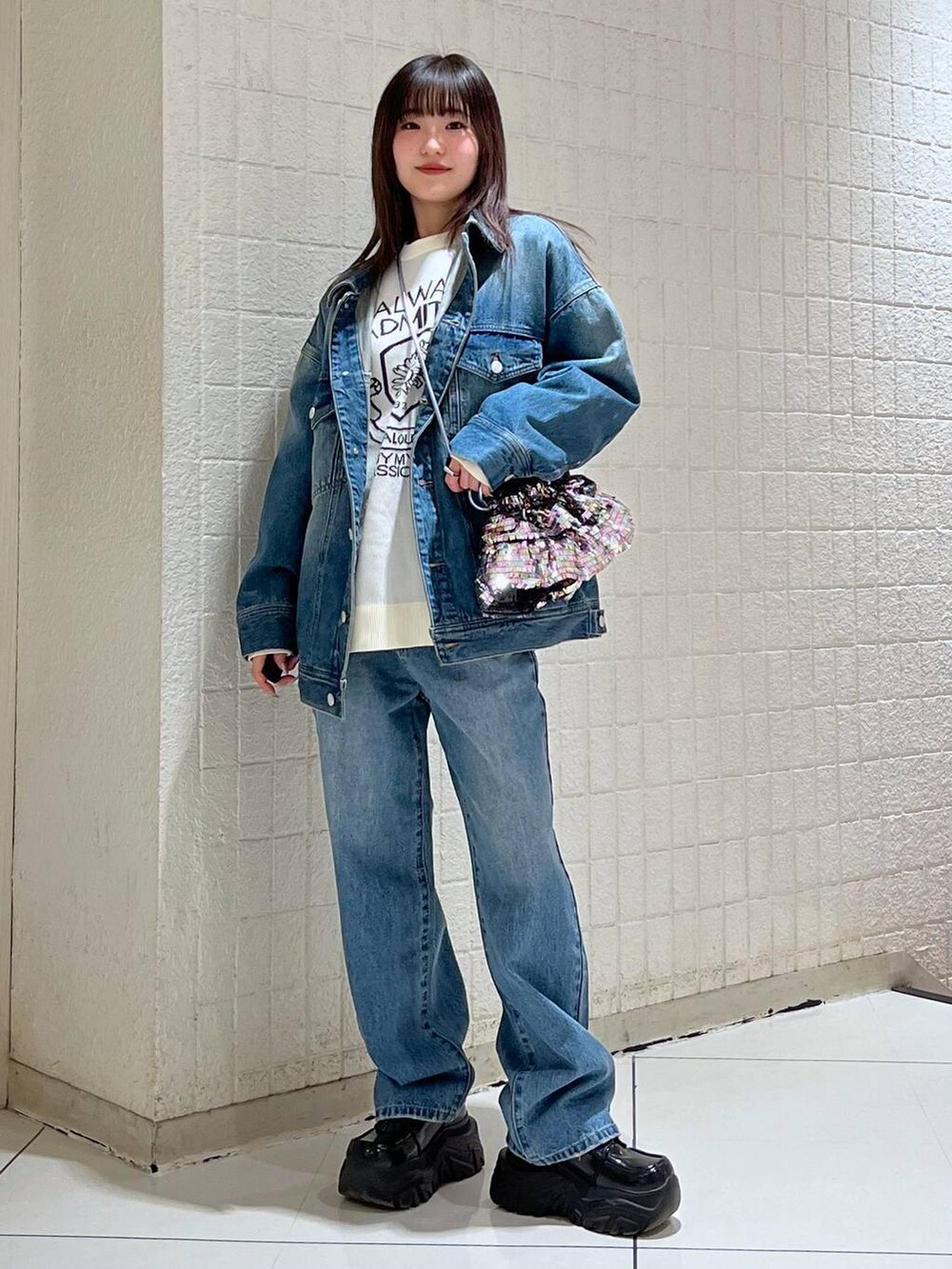 ホワイト系のニット/セーター、ブルー系のデニムジャケット、ブルー系のデニムパンツを着用したレディースの冬コーディネートの2枚目の写真