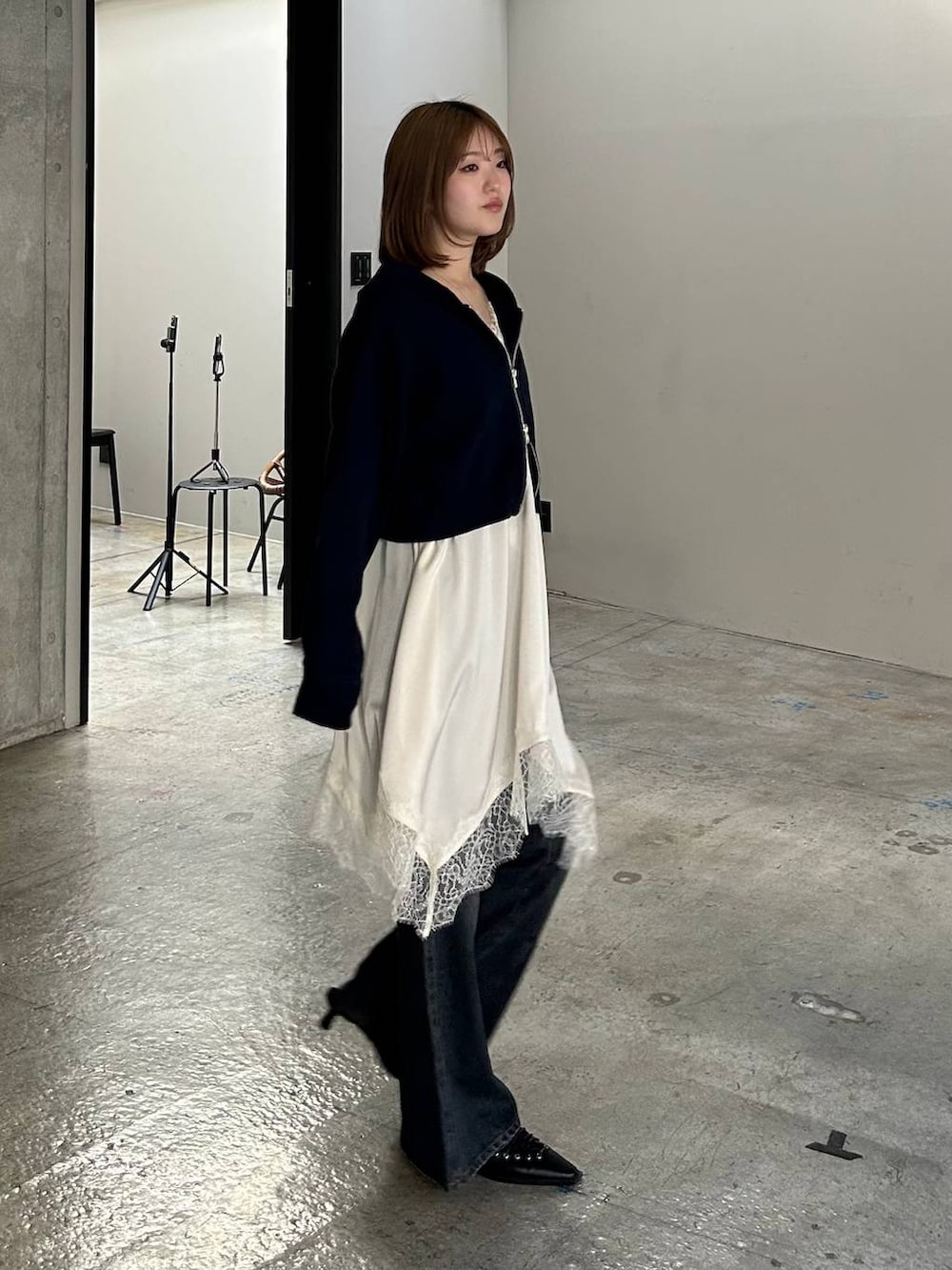 ブルー系のデニムパンツ、ブラック系のサンダル、ブルー系のパーカーを着用したレディースの冬コーディネートの4枚目の写真