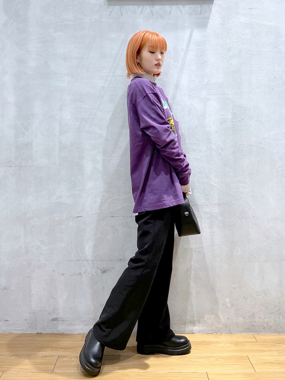 ブラック系のスラックス、ブラック系のショルダーバッグ、パープル系のTシャツ/カットソーを着用したレディースの秋コーディネートの2枚目の写真