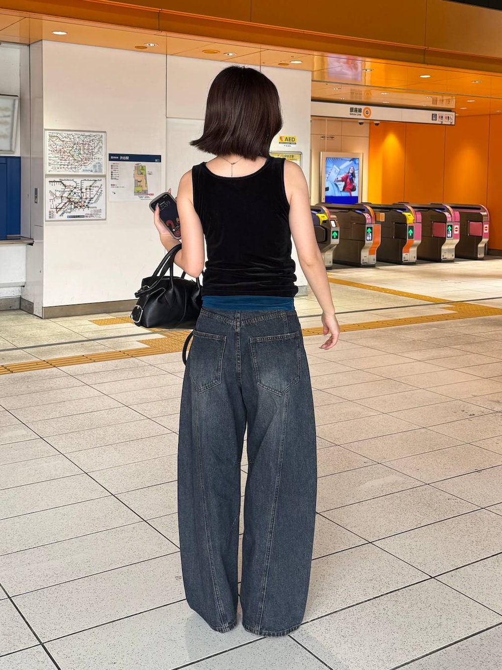 ブルー系のタンクトップ、ブラック系のタンクトップ、ブルー系のデニムパンツを着用したレディースの夏コーディネートの3枚目の写真