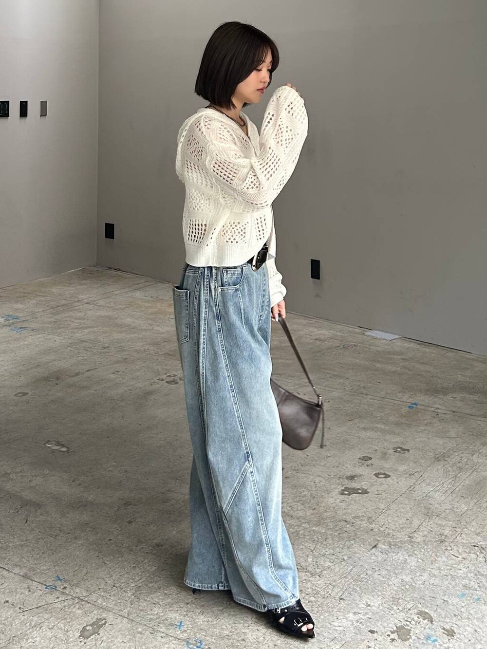 ホワイト系のキャミソール、ブルー系のデニムパンツ、ホワイト系のパーカーを着用したレディースの春コーディネートの4枚目の写真