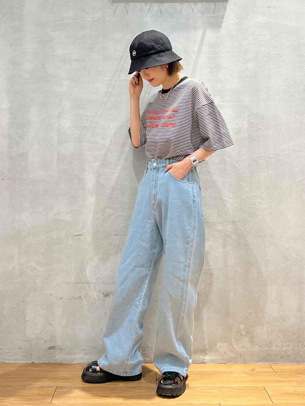 ブラック系のTシャツ/カットソー、ブルー系のデニムパンツ、ブラック系のハットを着用したレディースの夏コーディネートの4枚目の写真