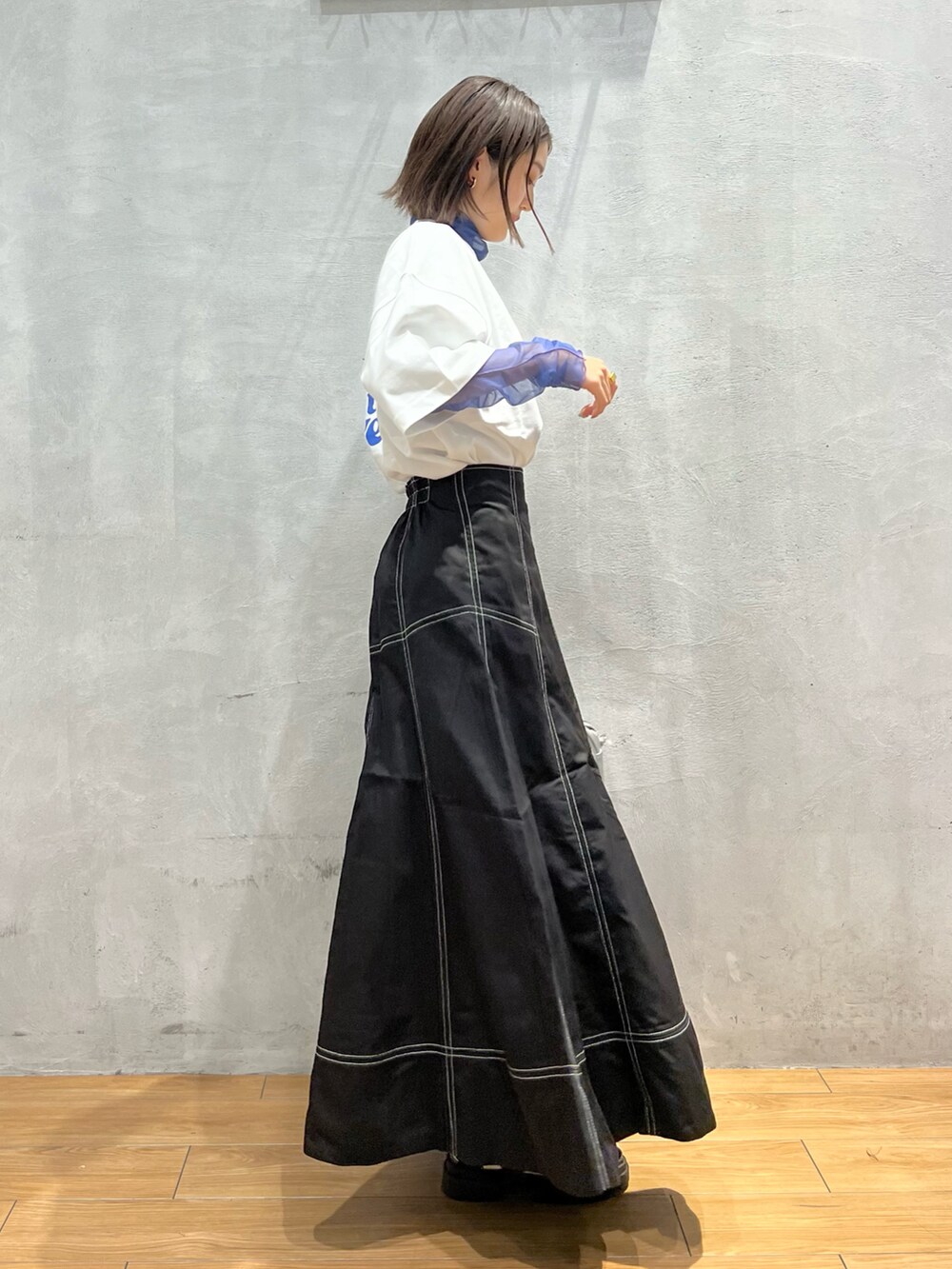 ホワイト系のサンダル、シルバー系のショルダーバッグ、ブラック系のスカートを着用したレディースの夏コーディネートの2枚目の写真