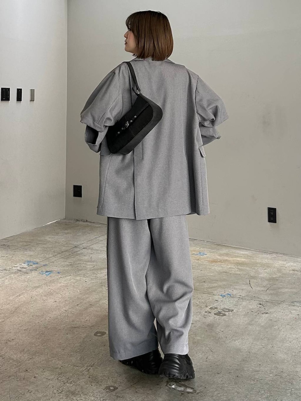 ブラック系のブーツ、ブラック系のキャミソール、ブラック系のハンドバッグを着用したレディースの春コーディネートの3枚目の写真