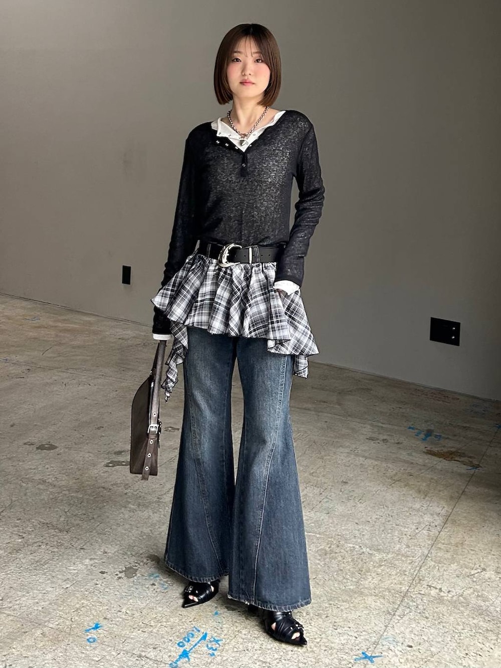 ブルー系のデニムパンツ、ブラウン系のハンドバッグ、ブラック系のTシャツ/カットソーを着用したレディースの春コーディネートの6枚目の写真