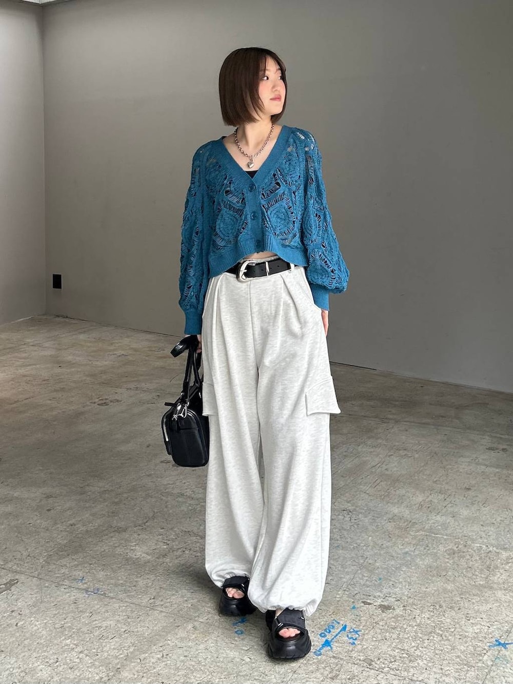 ブルー系のカーディガン/ボレロ、ブラック系のショルダーバッグ、ベージュ系のその他パンツを着用したレディースの春コーディネートの5枚目の写真